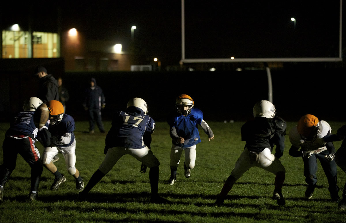 The Vancouver Bulldogs Pop Warner football team practices at Union High School by spotlight on Wednesday.