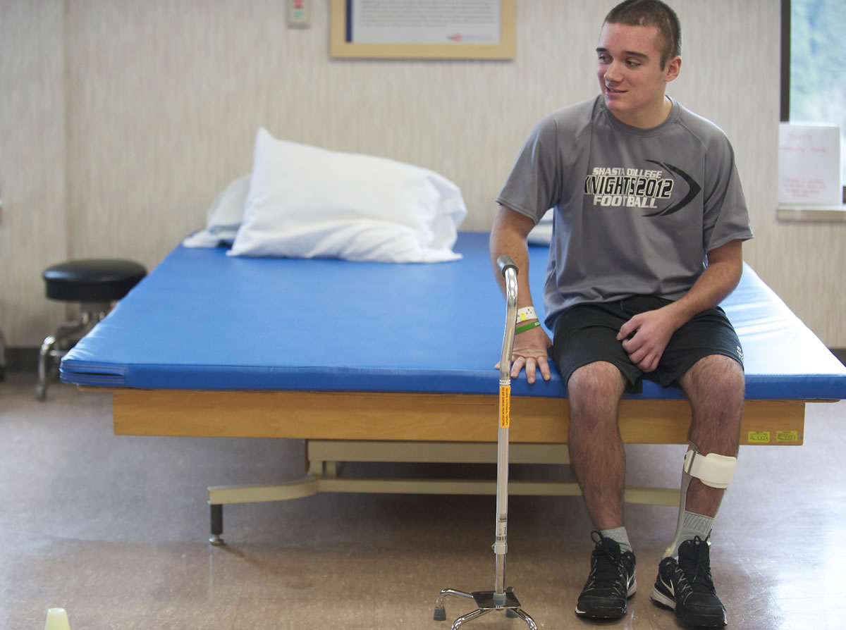 Tyler Burton, who suffered a brain injury in an assault in California last year, rests during a physical therapy session at PeaceHealth Southwest Medical Center on Monday.