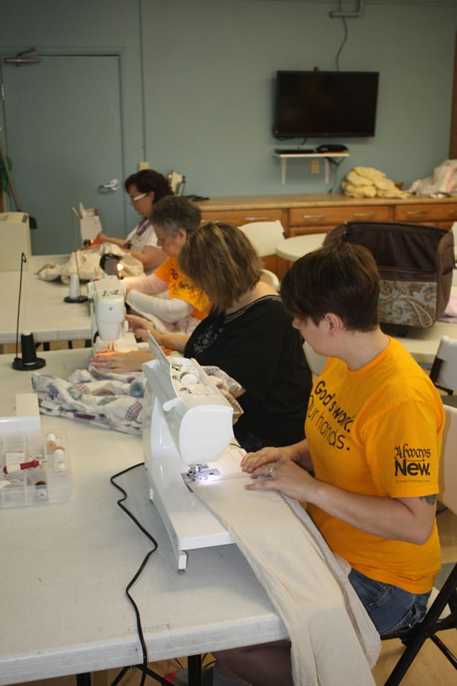 North Image: Maggie Antonelli, from foreground to back, Kari Pinc, Nadine Scott and Michelle Steele sew sheets for the WHO program.