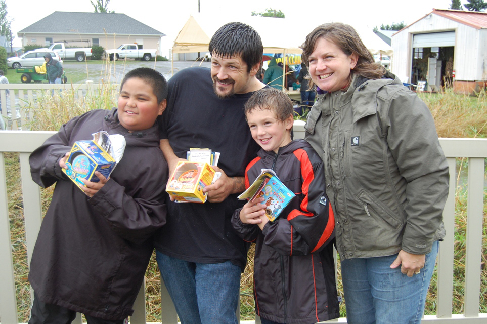 Hazel Dell: Champion pie eaters Edrianne Layog, 11; Johny Decoteau, 35; and Quentin Decoteau, 8, are congratulated by Susan Tissot, executive director of the Clark County Historical Museum during Harvest Fun Day.