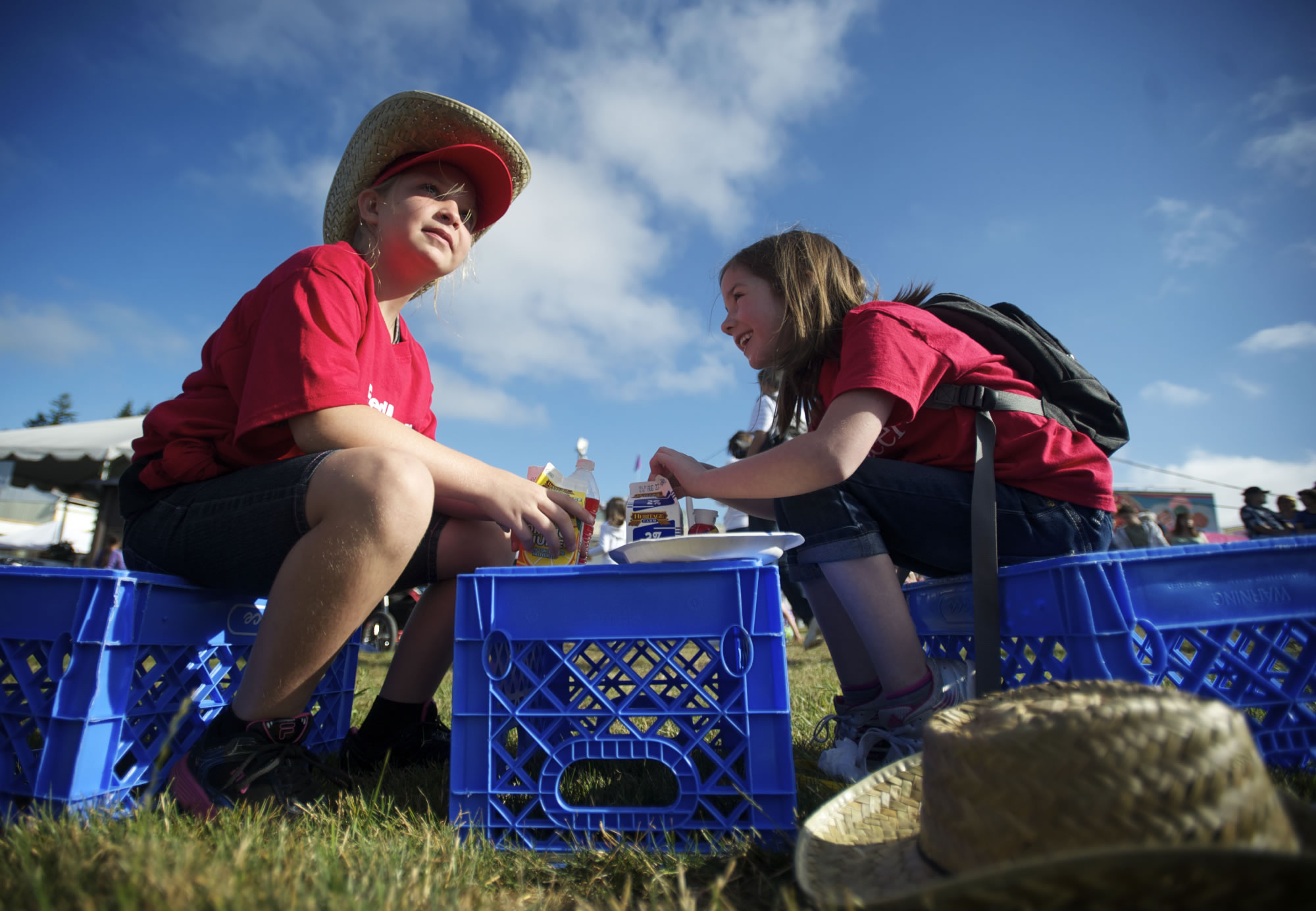 Volunteers Alecia Glaspey, left, 9, of Washougal, and Madison Johnson, 6, of Vancouver, sit down for breakfast during the annual pancake feed on the opening morning of the Clark County Fair on Friday.
