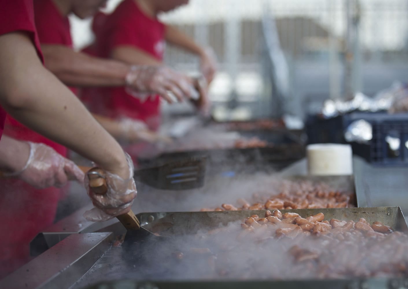 Volunteers fry up sausages for the thousands of people who took advantage of the free breakfast sponsored by Fred Meyer on the opening day of the Clark County Fair.