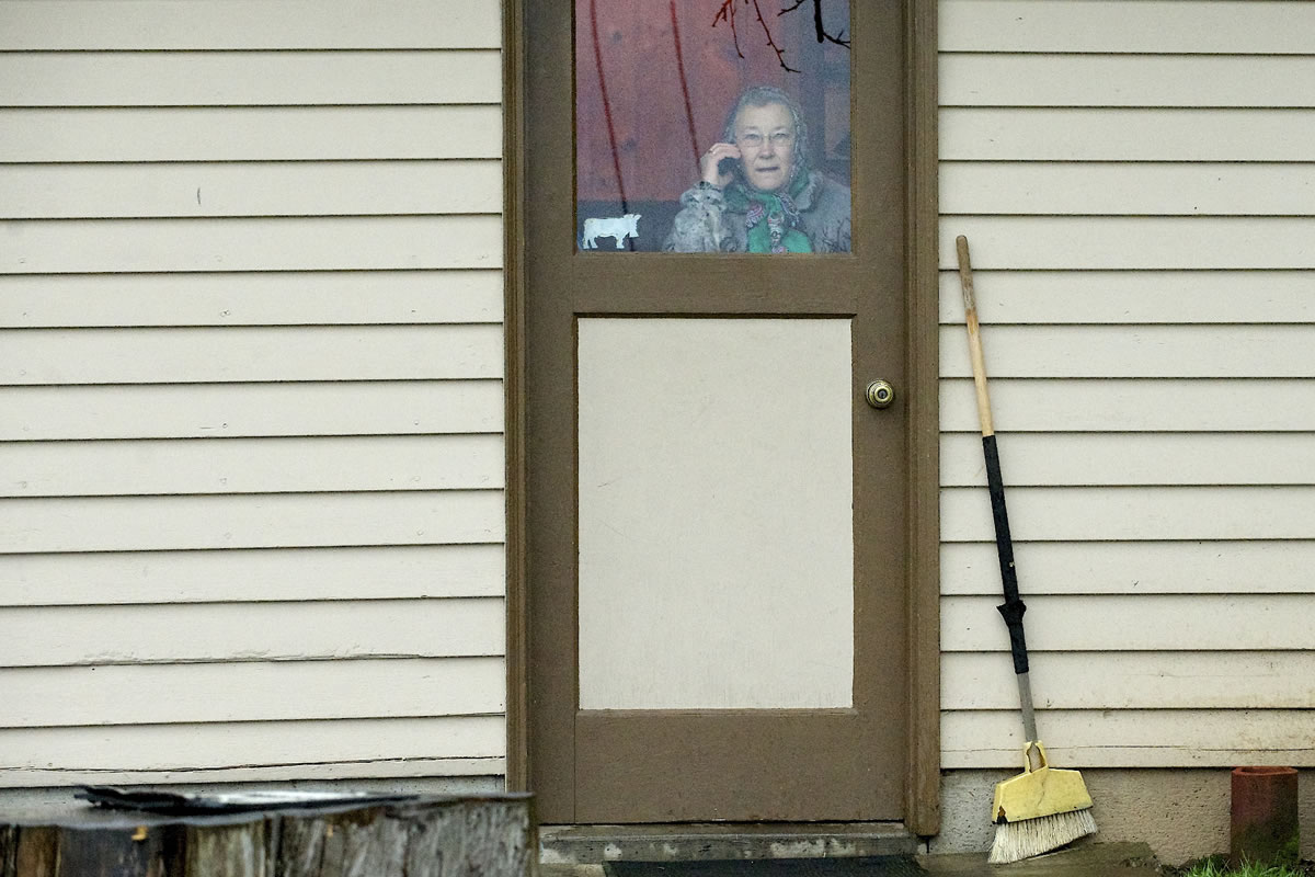 Delores Matson watches from her back door as firefighters control a shop fire near the Matsons' house.