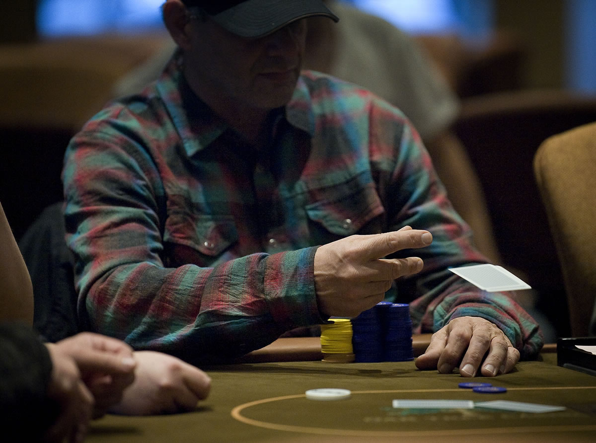 A poker player folds during a Texas Hold 'Em tournament at the Oak Tree Casino in February.
