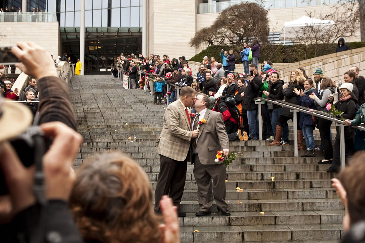 Brad McCanta, 48, left, and Jay McCanta, 52, both of Seattle, share a kiss on the steps of Seattle City Hall after being married Dec.