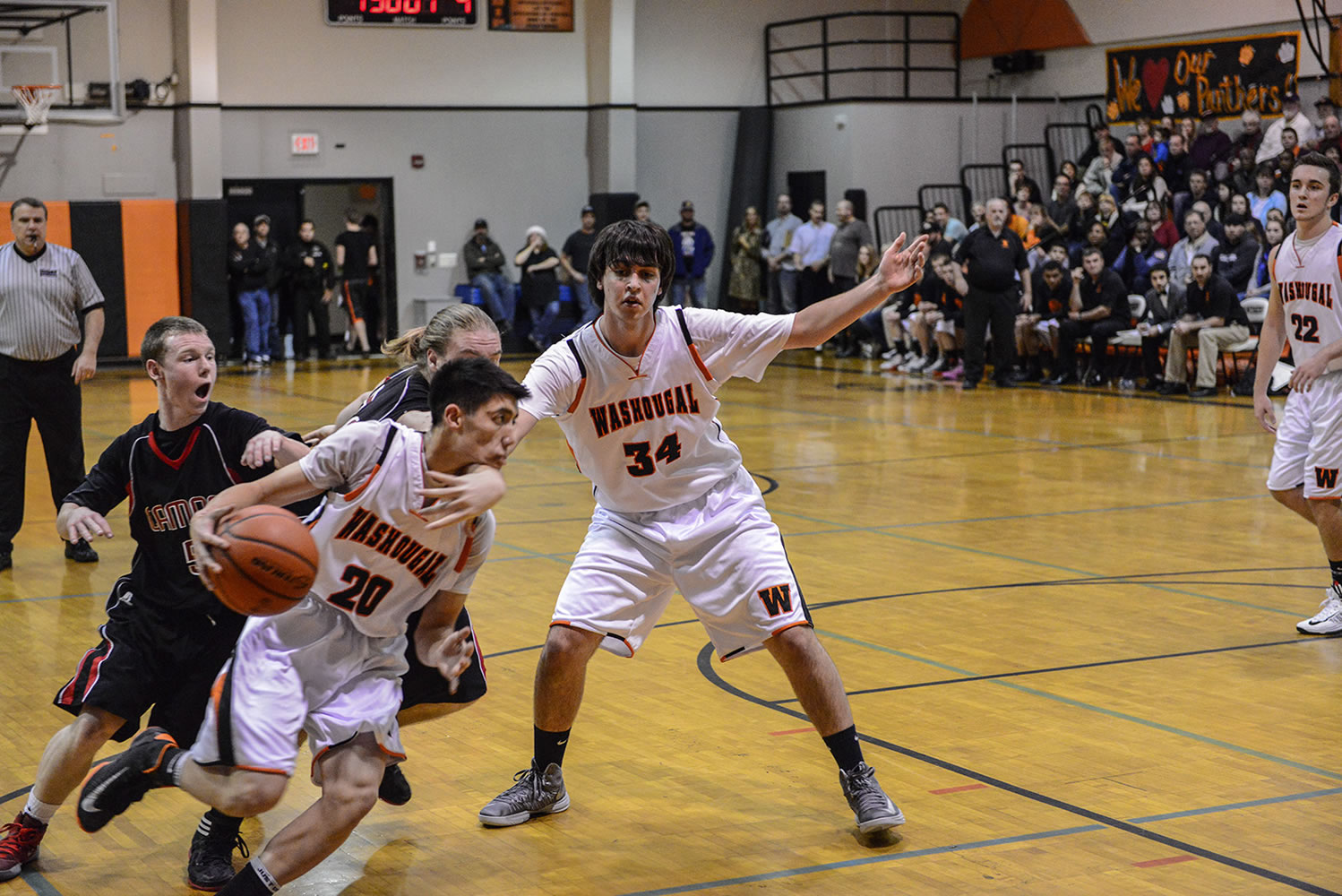 Washougal's Austin Tran rolls by Camas defenders Trent Johnson and Drew Clarkson on a pick set by Aaron Deister.