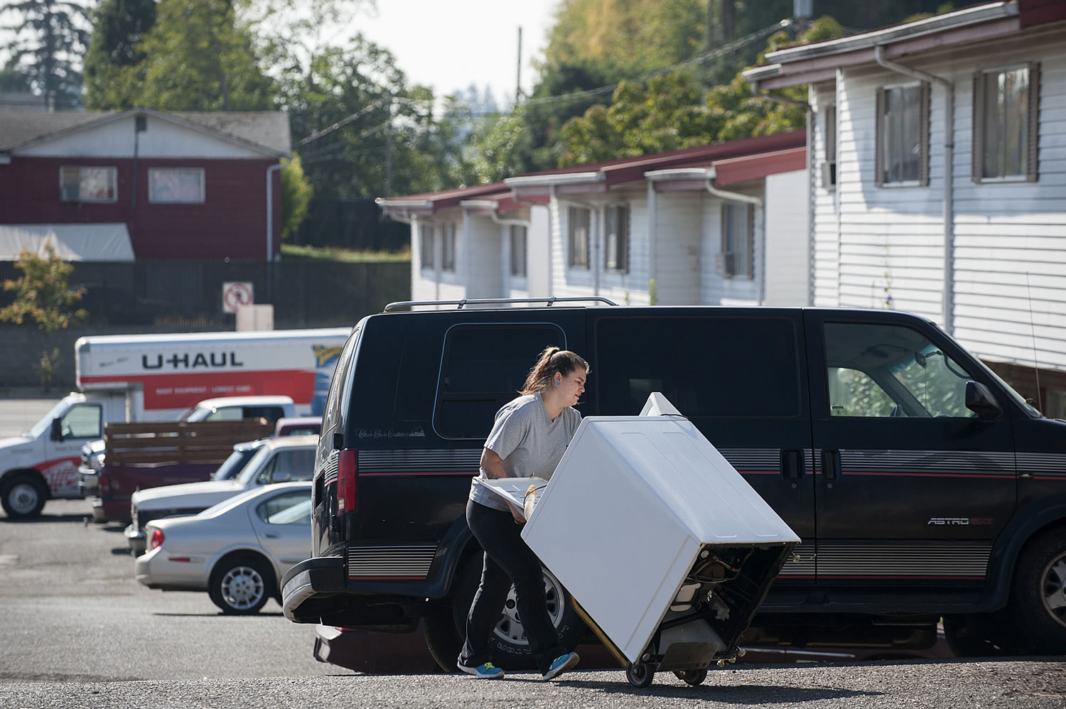 Ghim Village resident Tiffany Shepherd makes her way through the parking lot with her washer on Sept. 30. A friend who&#039;d borrowed the washer was moving out. Residents of the low-income complex were given 22 days notice to leave, forcing them to find new housing during a time of rising rents and low vacancy rates.