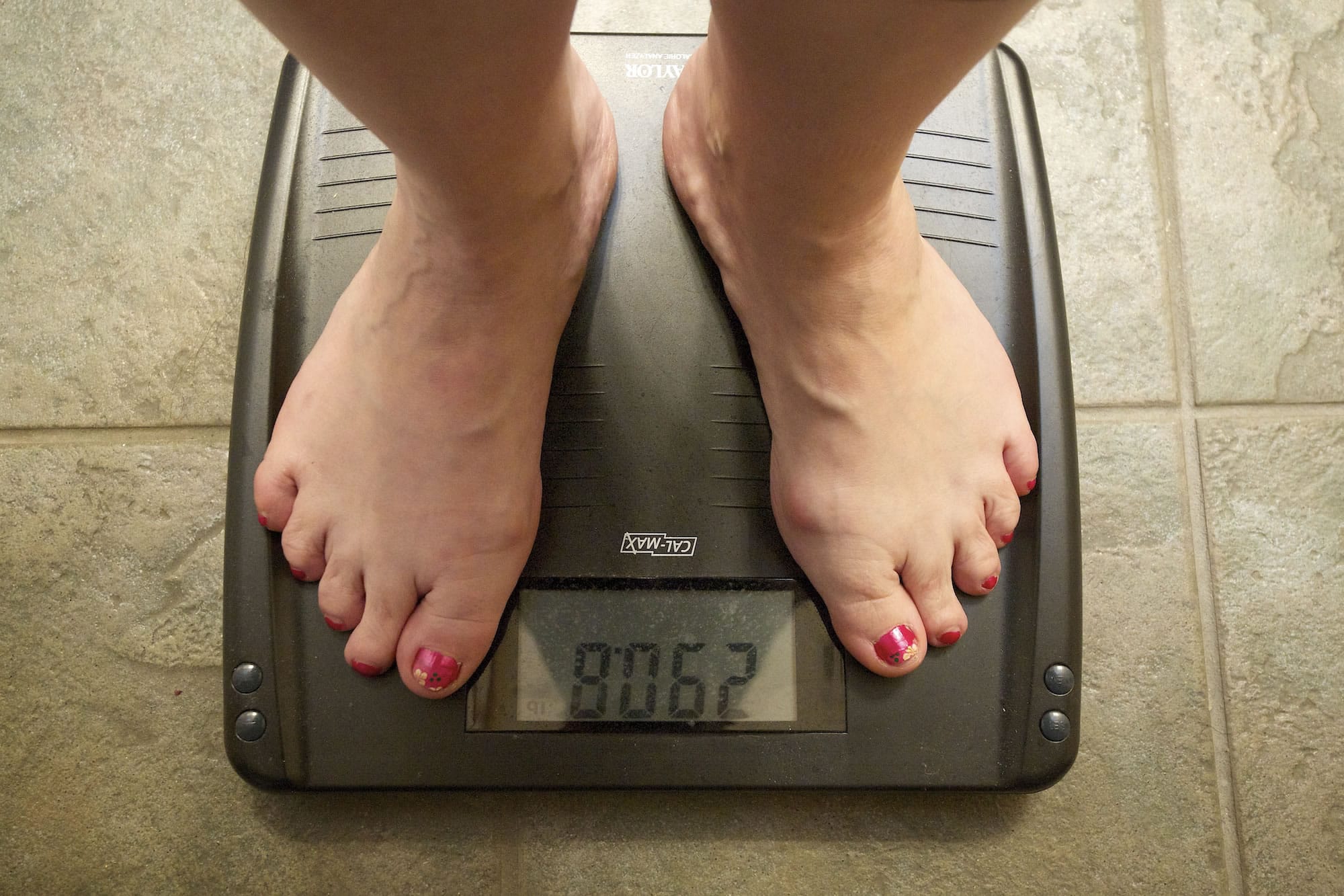 Laina Harris steps on the scale in her Camas home Wednesday. Harris weighs herself every day to monitor her weight-loss progress.