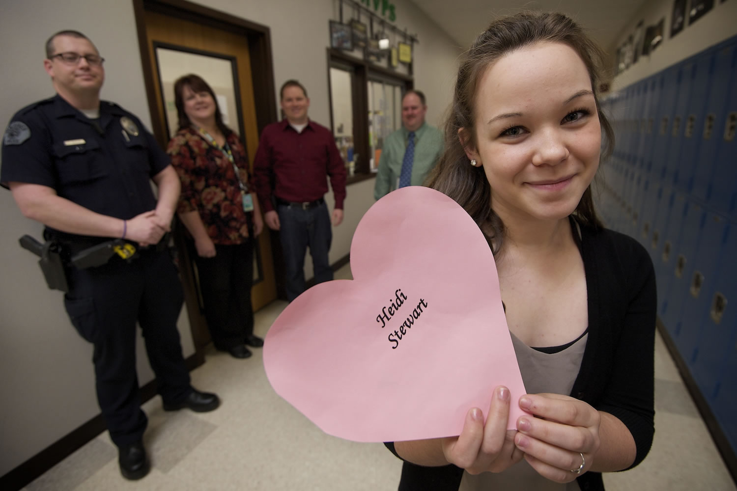 Heidi Stewart, 18, a senior student at Evergreen High School, holds a paper heart with her name printed on it. She collapsed at school in February after suffering sudden cardiac arrest. Helping her that day, from left to right, are Eric McCaleb, Dianna Lynch, Reuben Dohrendorf and Marshall Pendleton.