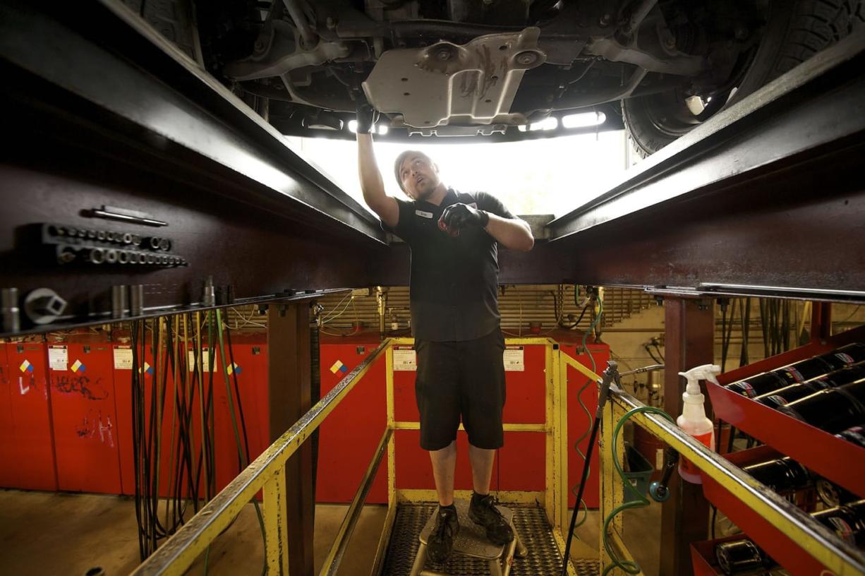 Eric Campbell changes the oil on a vehicle for a customer at Autumn's Auto Lube in Vancouver.