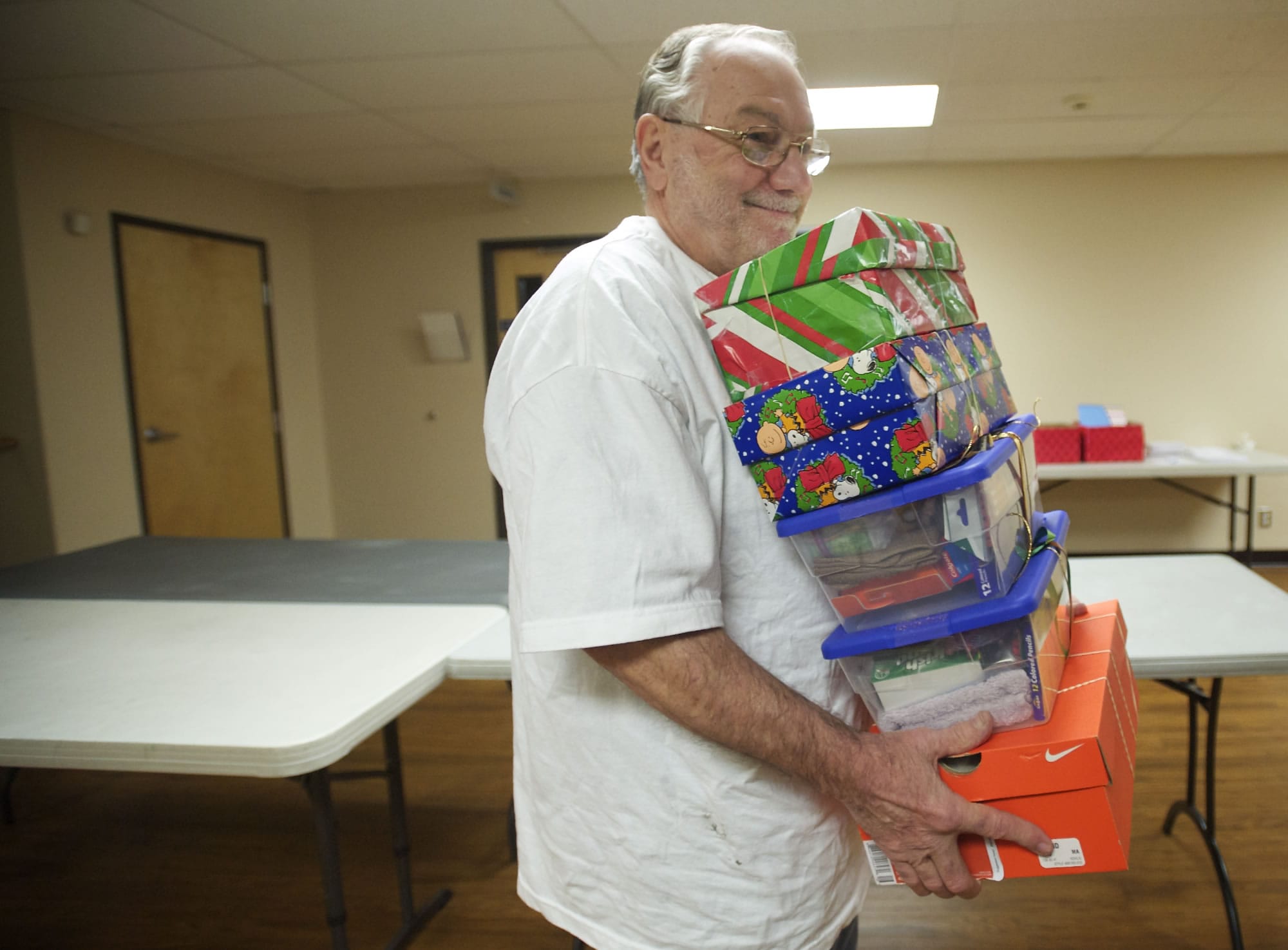 On Saturday, volunteer John Benson, 76, of the First Evangelical Church carries off gift-filled shoe boxes that will be distributed to needy children in 130 countries.