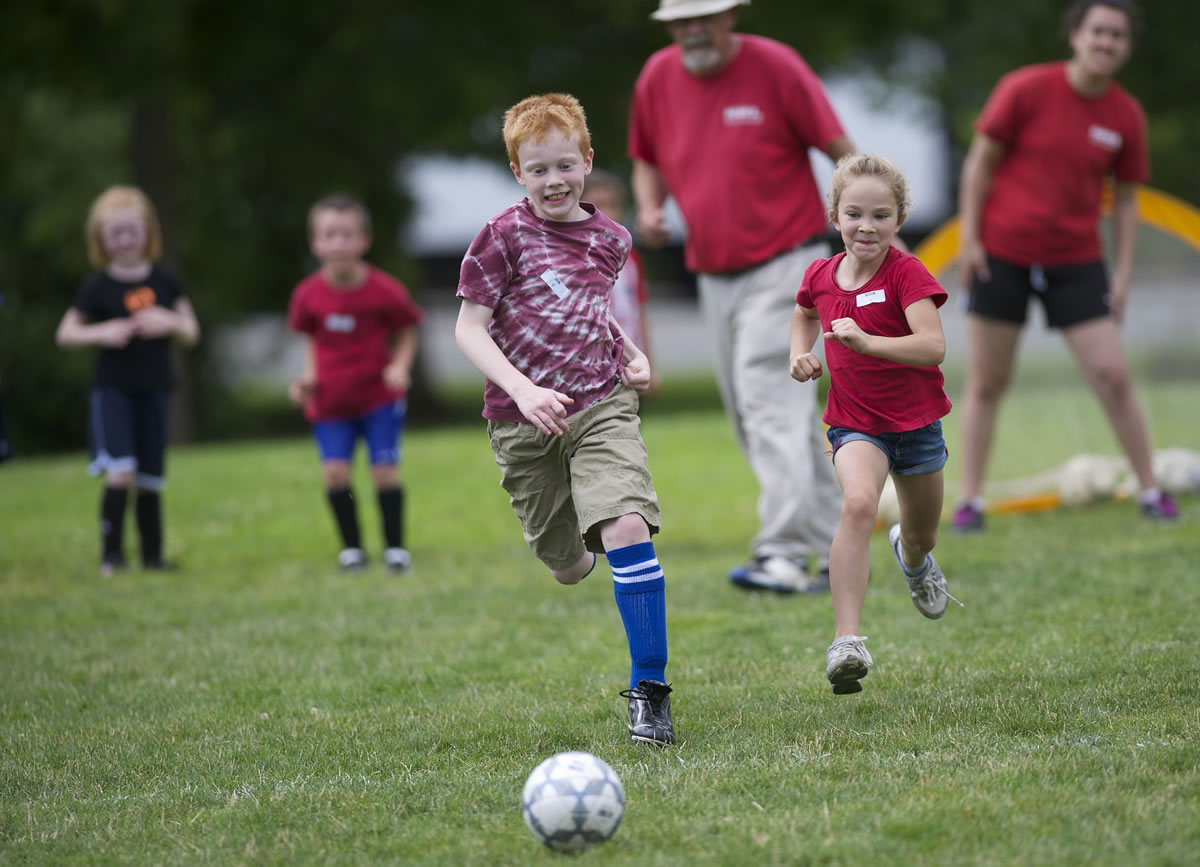 Ian York, 9, and Kasia Rinier, 7, battle for a soccer ball Thursday during a Vancouver-Clark Parks &amp; Recreation mini sports camp at Marshall Park.