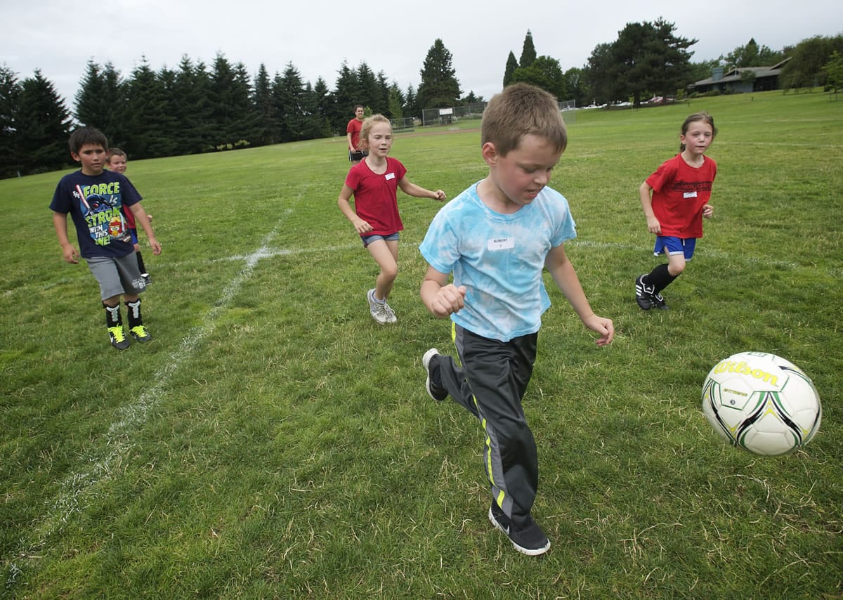 Children participate in soccer drills during a mini sports camp at Marshall Park on Thursday.