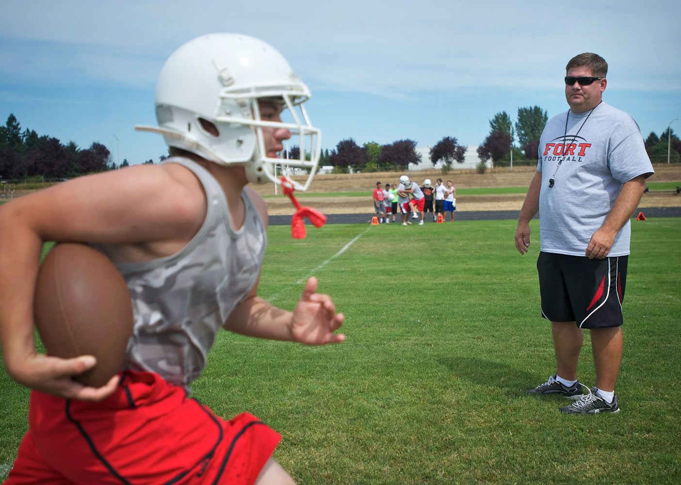 Angel Bonilla, 16, runs past Fort Vancouver's new head coach Todd Quinsey during the Trappers' first practice Wednesday.
