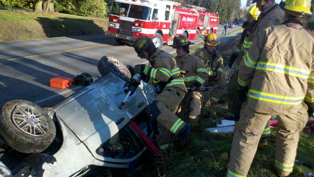 Firefighters tend to a woman injured in an auto accident this morning.