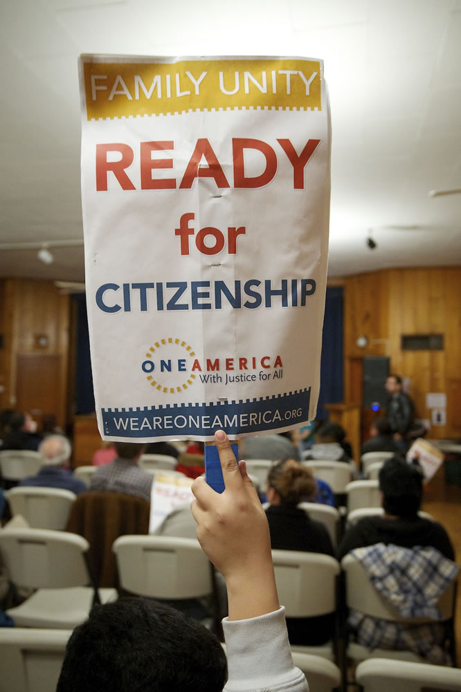 A OneAmerica rally attendee holds up a sign in support of comprehensive immigration reform during a rally Tuesday at St.