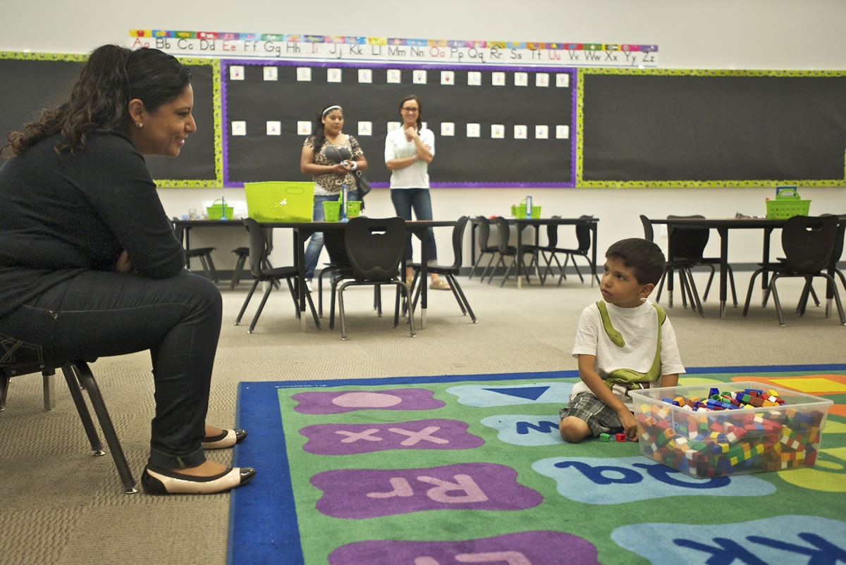 Kindergartner Jonathan Martinez, 5, looks toward his mother, Esmeralda Martinez, while playing with plastic cubes in his new classroom.