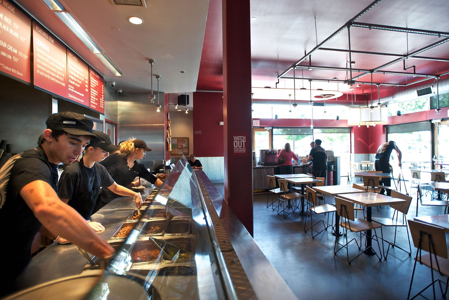 Vincent Mendez, left, and his colleagues get ready to serve the lunch crowd Tuesday at Chipotle Mexican Grill in east Vancouver.