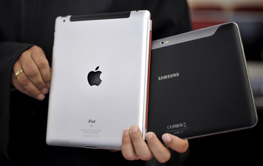 In this Aug. 25, 2011 file photo, an attorney holds an Apple iPad, left, and a Samsung Galaxy Tab 10.1 at the regional court in Duesseldorf, Germany. The two tech Titans will square off in federal court Monday, July 30, 2012, in a closely watched trial over control of the U.S. smart phone and computer tablet markets. Apple Inc. filed a lawsuit against Samsung Electronics Co.