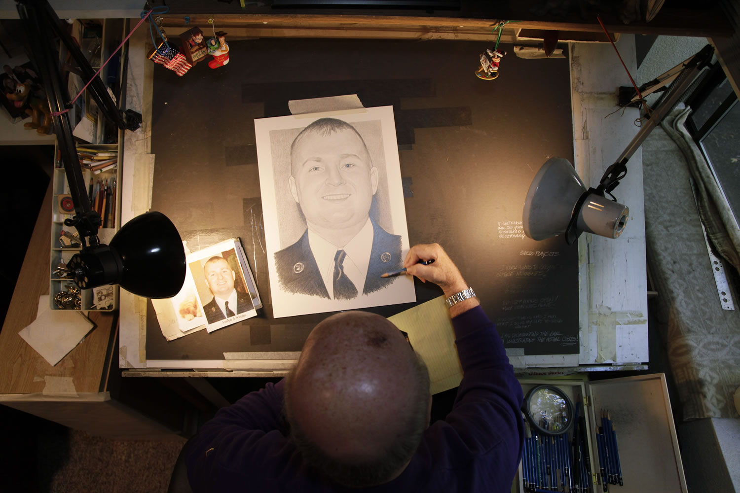 In this Thursday, Oct. 4, 2012 photo, artist Michael Reagan works on a portrait of Joseph A. Weems, who died after being  after being hit by a train while riding his bicycle near the Ramstein Air Base in Germany as he served in the U.S. Air Force at his home in Edmonds, Wash.