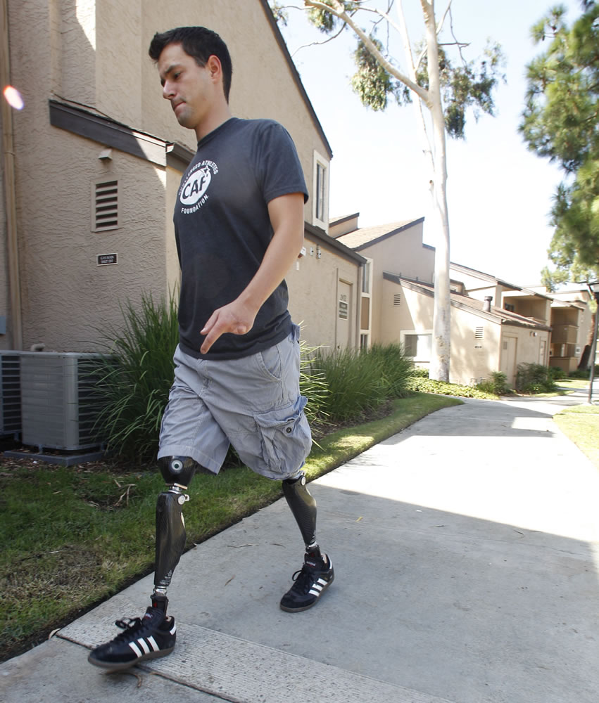 In this Thursday, Oct. 4, 2012 photo, former U.S. Marine Cpl. Daniel Riley, 21, walks with prosthetic legs outside his apartment in San Diego.  Riley lost both legs to an IED in Afhganistan. Learning to walk on his prosthetic legs was &quot;like kicking a soccer ball in a swimming pool.&quot; But he didn't just learn to walk; he has learned to soar.