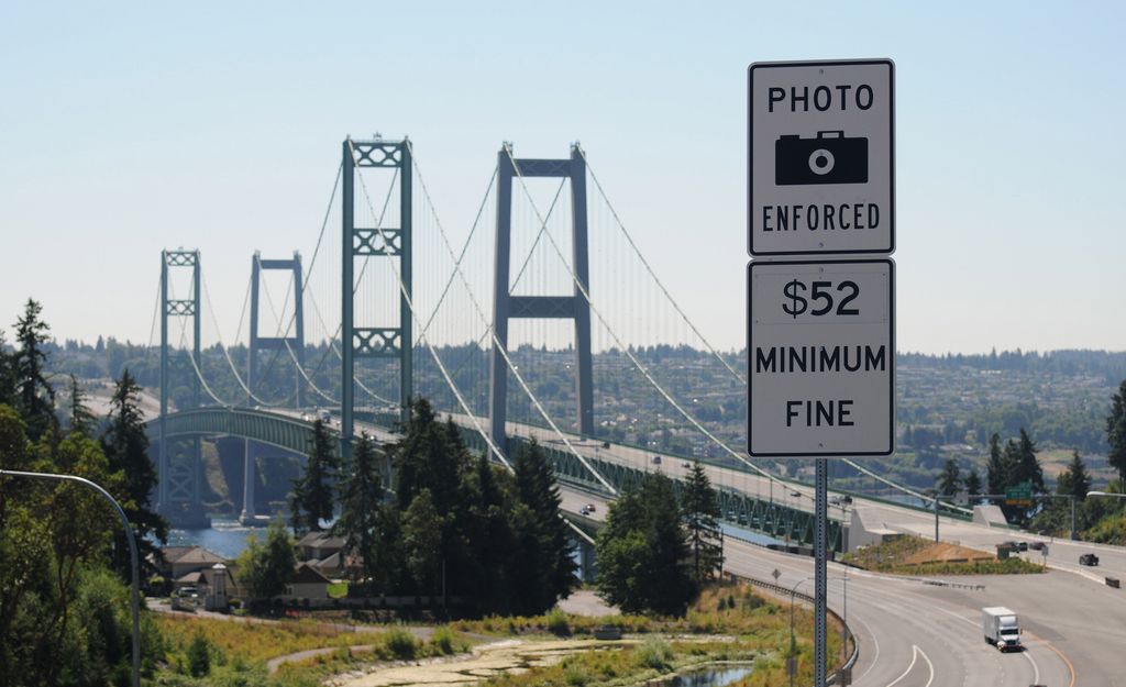 Signs warn drivers of the consequences of not paying tolls at the Tacoma Narrows Bridge.