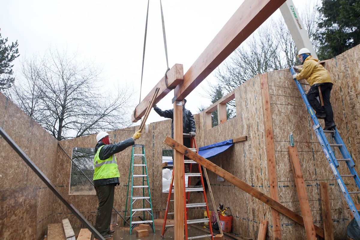 Crews place roof beams in the Emerald House project, which was designed to showcase a series of environmentally friendly features.