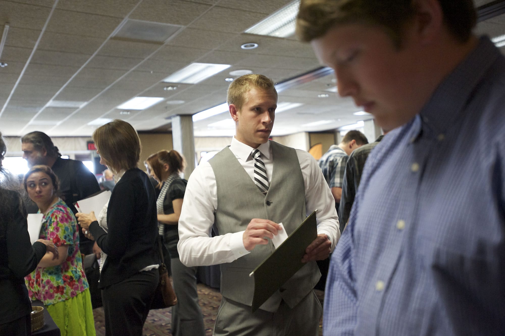 Braden Lewallen, 22, of Camas, who graduated from Washington State University with a political science degree, gets in line to talk to recruiters at a job fair hosted by Rep. Jamie Herrera Beutler at the Red Lion at the Quay on June 10.
