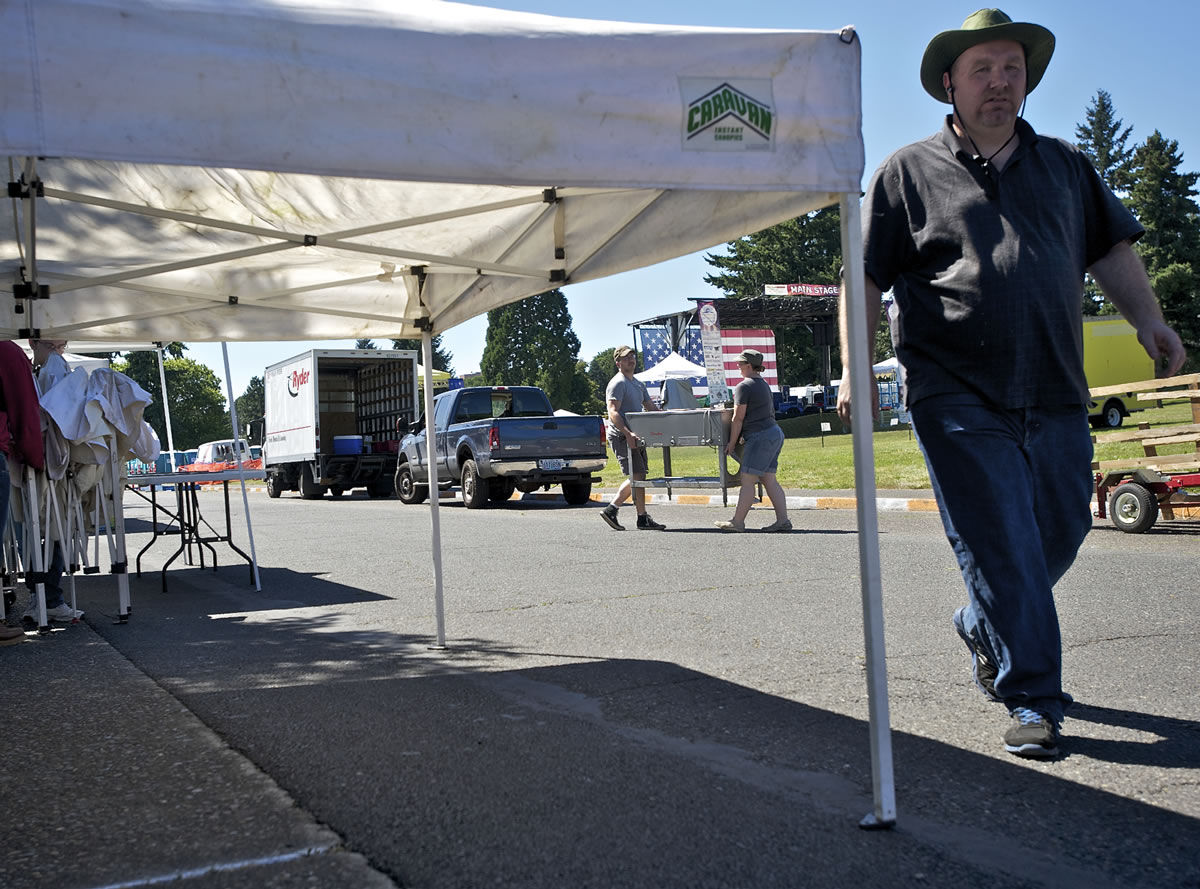 David Ullom of Ridgefield sets up his Fort Burger stand Wednesday next to other vendors in preparation for the Fourth of July celebration at Fort Vancouver. Ullom, in his fifth year as a vendor at the event, says it can be a business gamble with weather and other wildcard factors, but, he adds, it's a lot of fun. Four out of his five children will be working the booth this year.