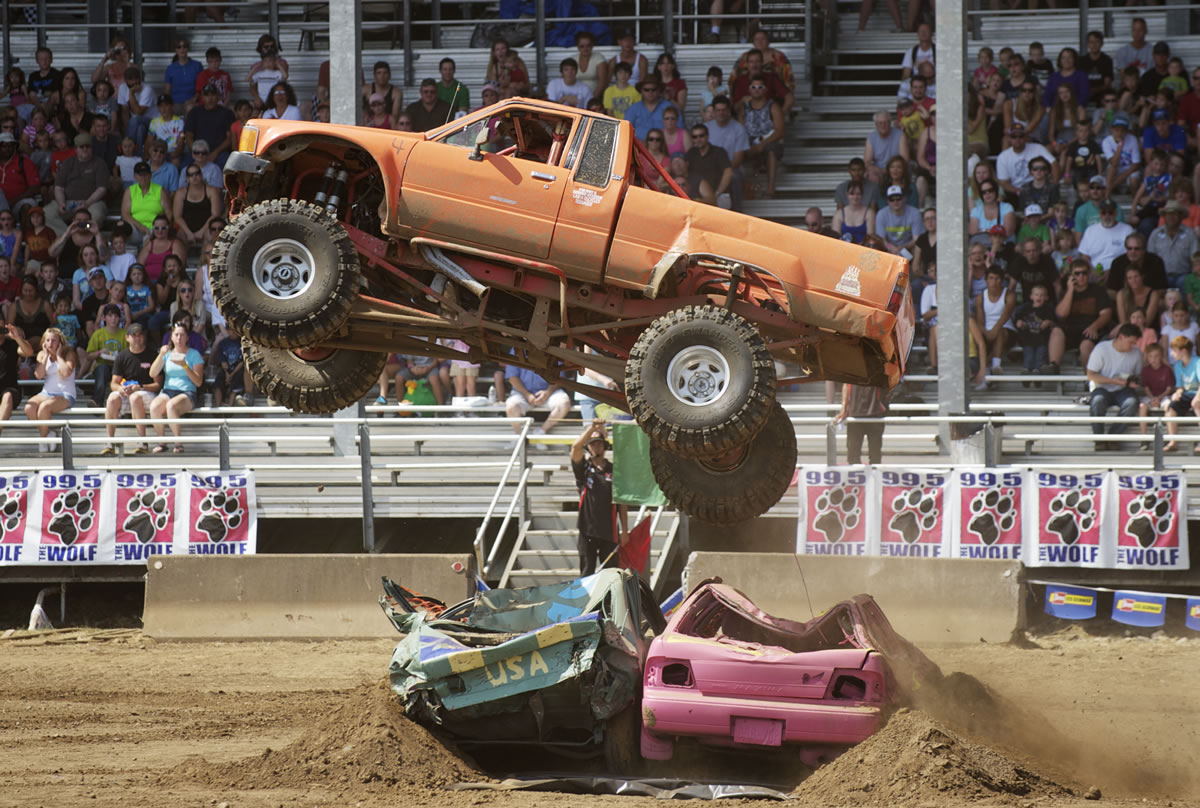 Bob Miller, 76, of Naselle jumps two cars in his converted Toyota pickup  during the Monster Truck Show at the Clark County Fair.