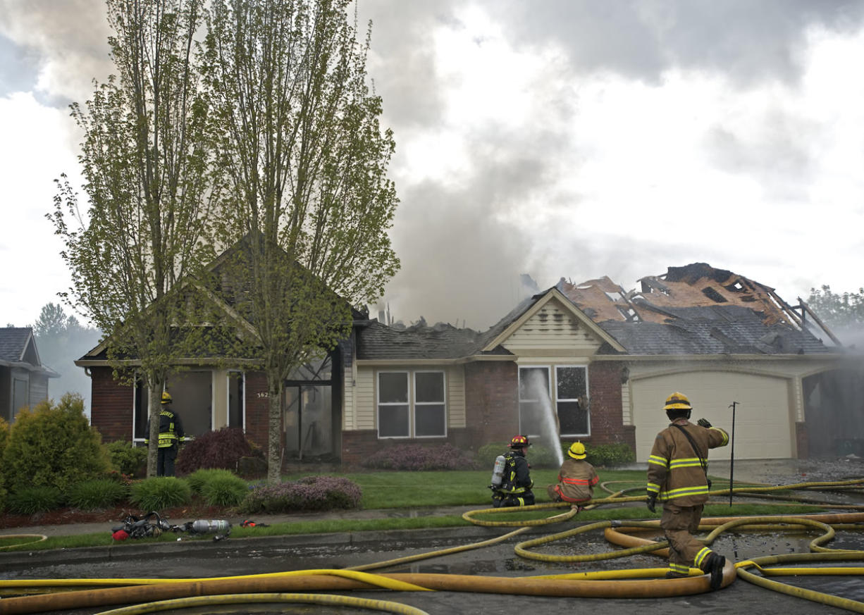Firefighters work to extinguish a fire that destroyed a Camas house Tuesday afternoon.