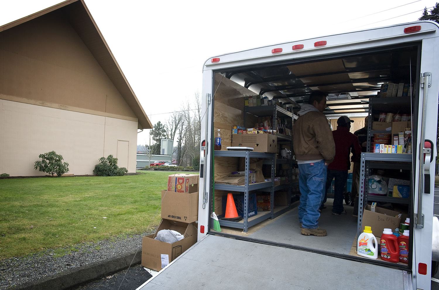 A family picks out food from the Lewis River Mobile Food Bank trailer which visited the La Center Free Evangelical Church in January 2011.