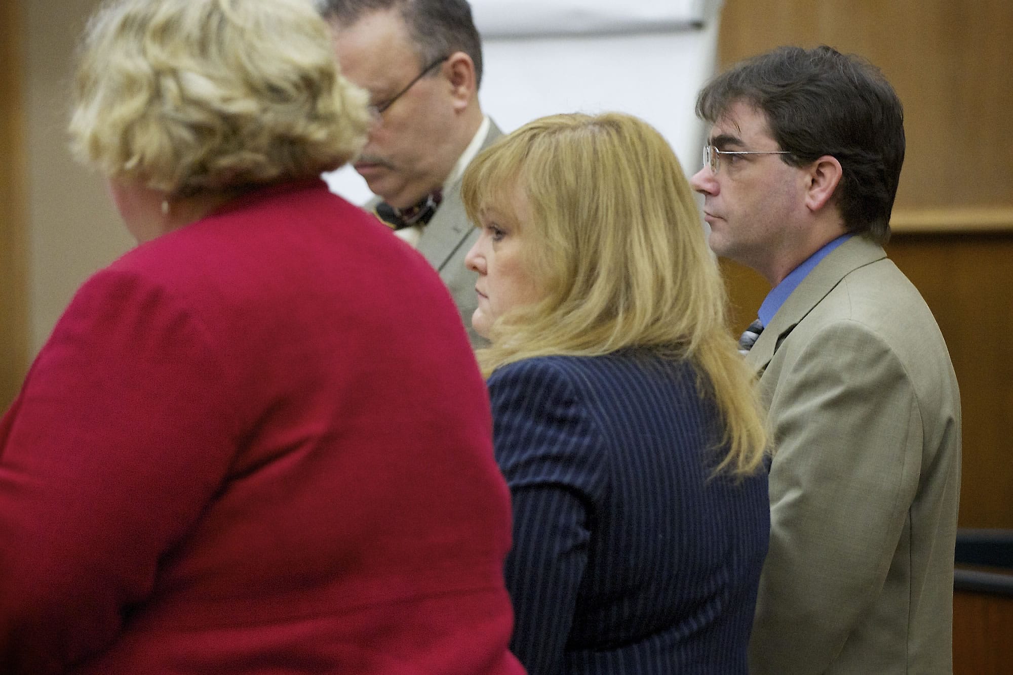 Sandra Weller, center, and Jeffrey Weller, background right, stand as the jury enter the courtroom for the start of their trial Tuesday.