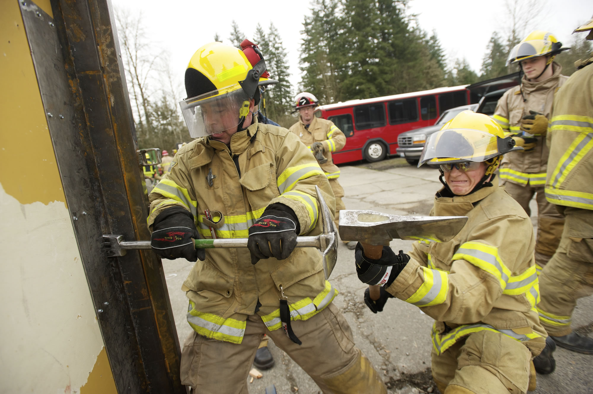 Clark County Fire and Rescue firefighters Zach Johnson, left, and Pavel Zabolotskiy use a Halligan tool to force entry through a door during a training exercise Thursday.