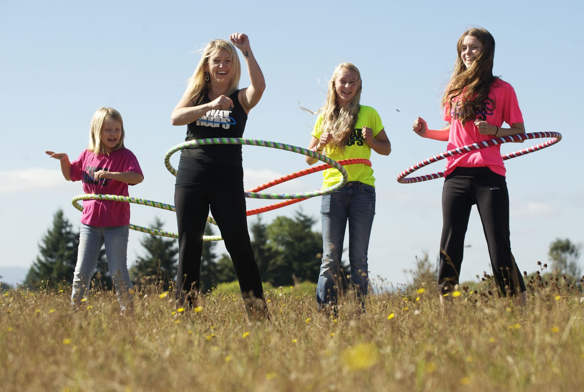 Trina Latshaw, second from left, creator of Phat Hoops, and her daughters, from left, Jordan, 9, Julia, 13, and Madison, 19, demonstrate the fitness hoops Tuesday.