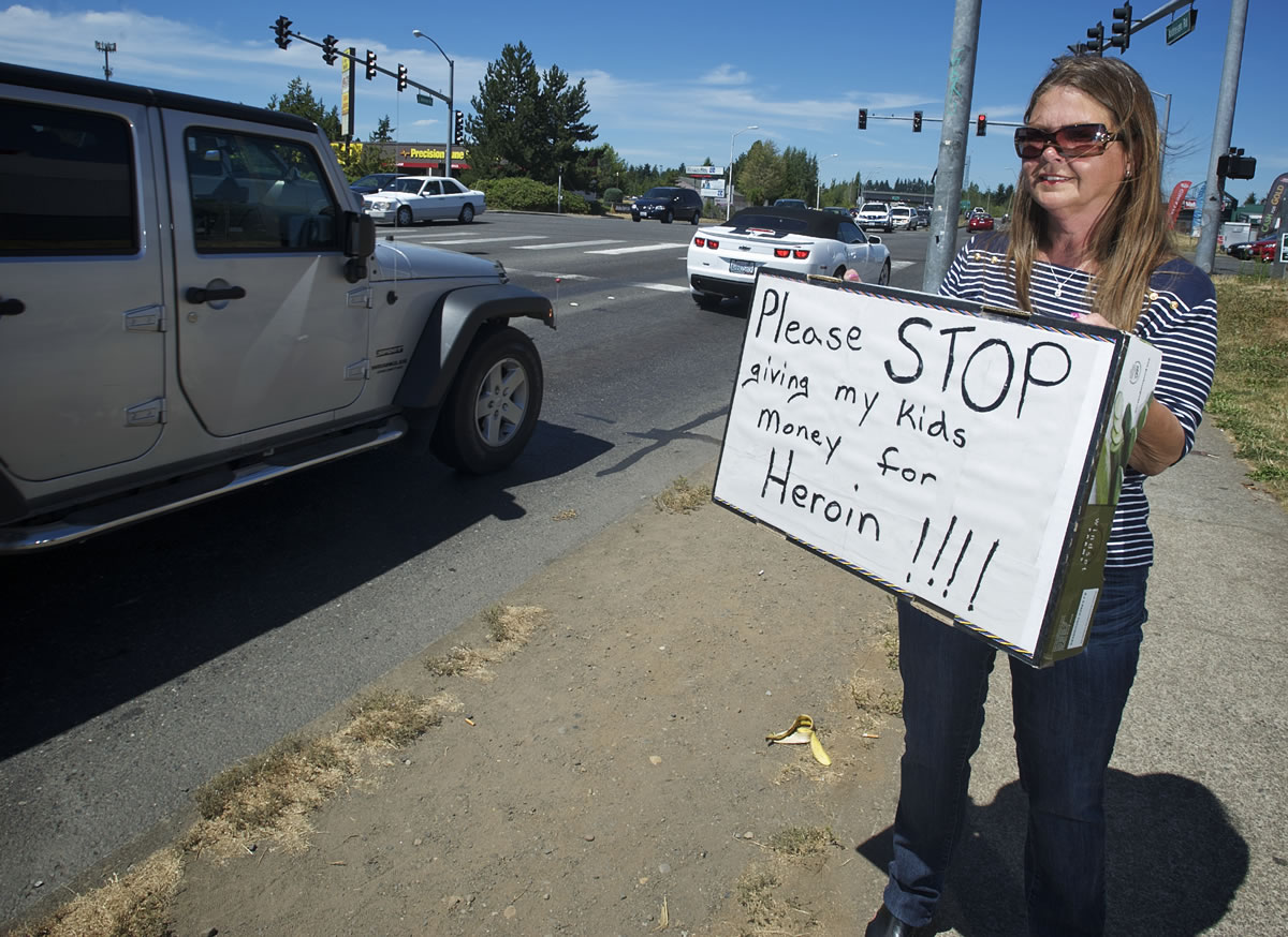 Teri Joy holds her sign at Northeast Fourth Plain Boulevard and Andresen Road, asking motorists not to give panhandlers money because she believes most of the charity contributes to drug addictions.