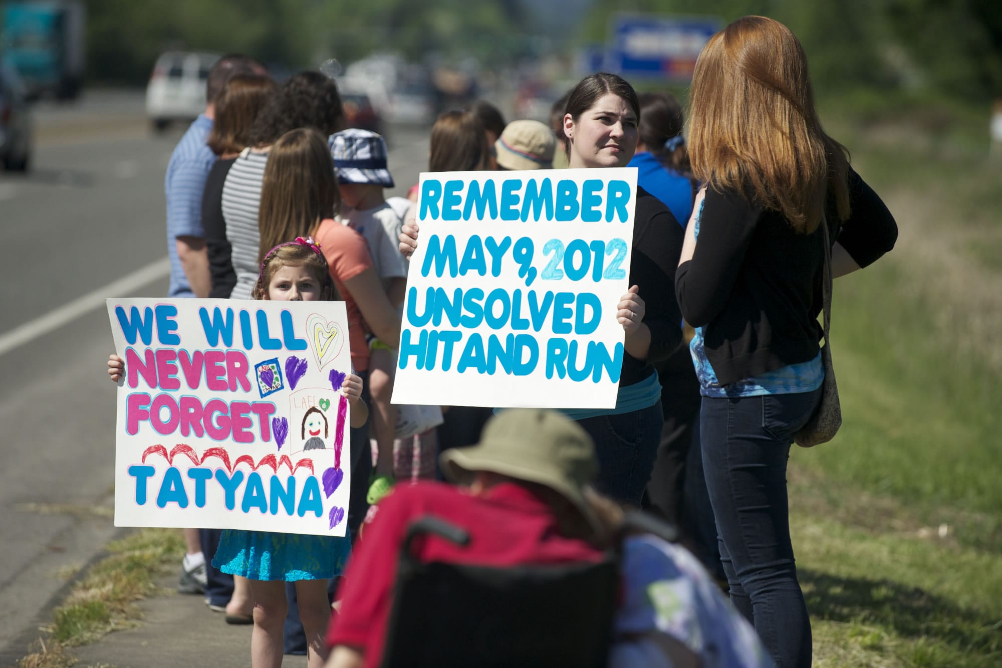 Coworkers, who worked with Tatyana at an assisted living facility in Battle Ground, hold signs facing Highway 503 to remind people of Tatyan's unsolved death.