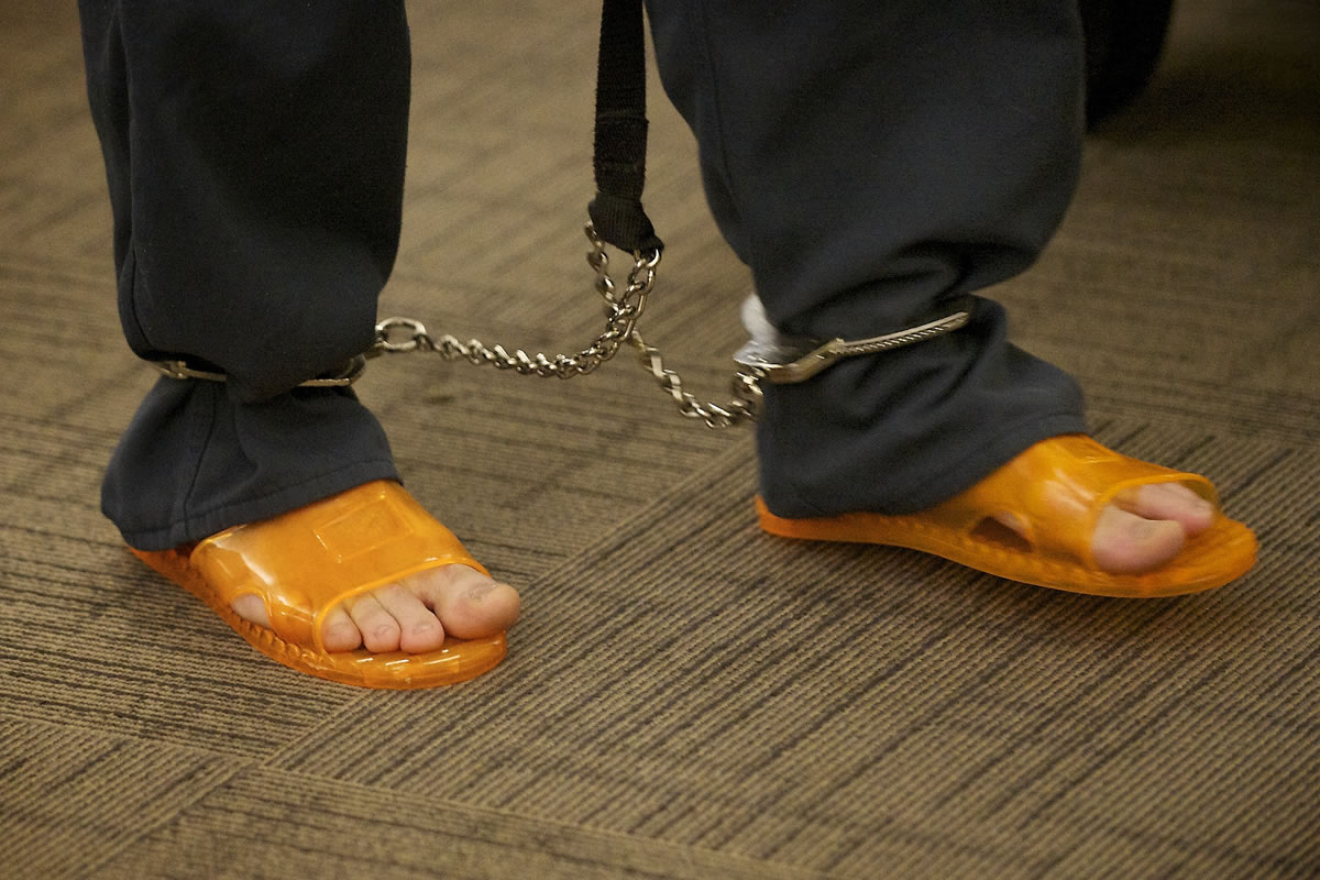An inmate shuffles into Clark County Superior Court earlier this spring, wearing shackles and orange plastic sandals.