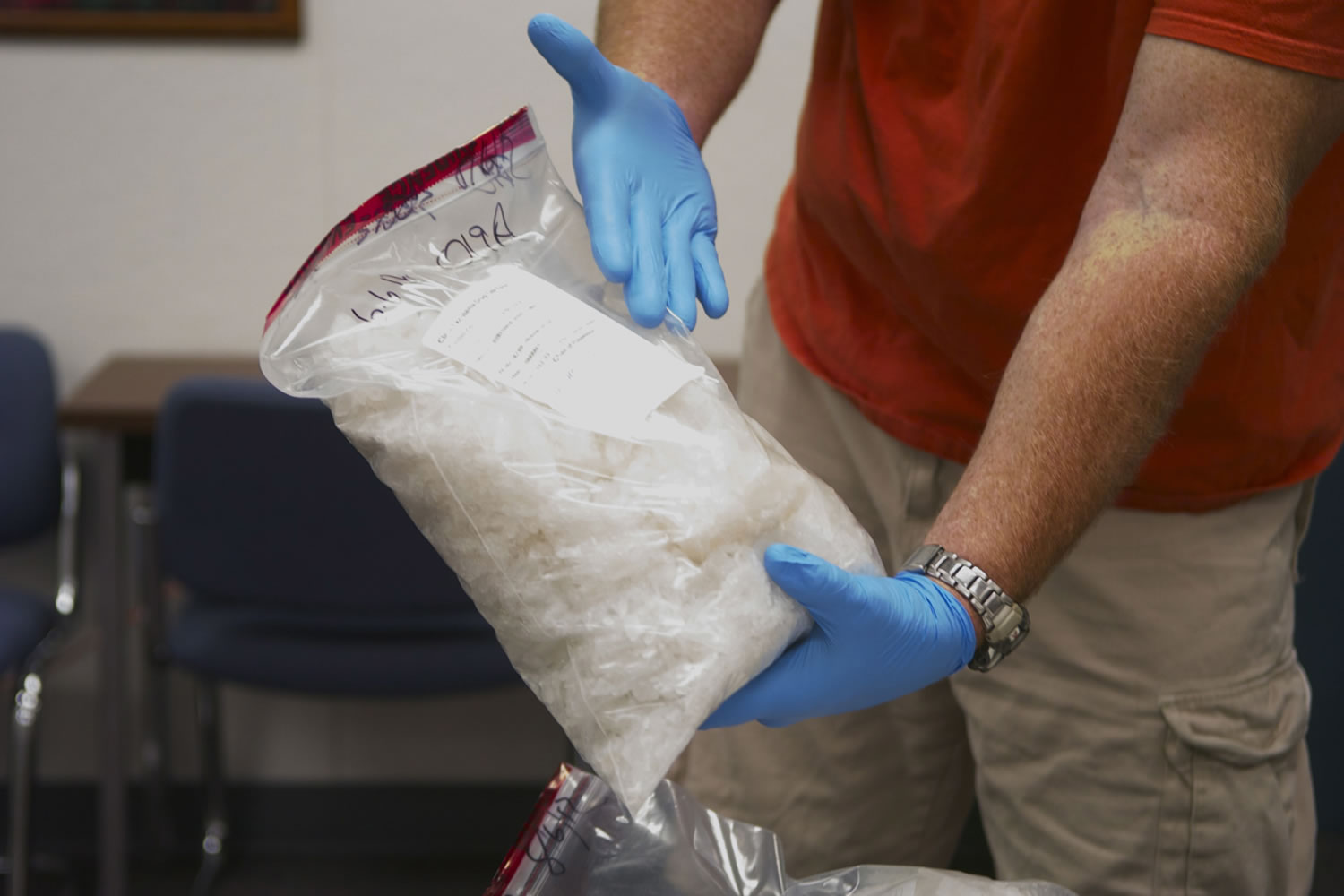 A Clark-Vancouver Regional Drug Task Force detective collects individual bags of methamphetamine in the Clark County Sheriff's Office headquarters Wednesday.