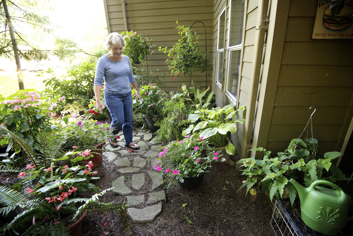 Teri Clark walks through her shade garden, one of many she keeps us with husband Bob.