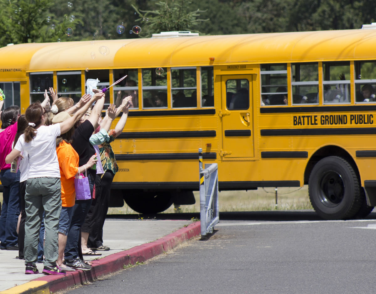 Teachers blow bubbles and wave goodbye to students after the last day of school at Daybreak Primary and Middle schools on Tuesday.