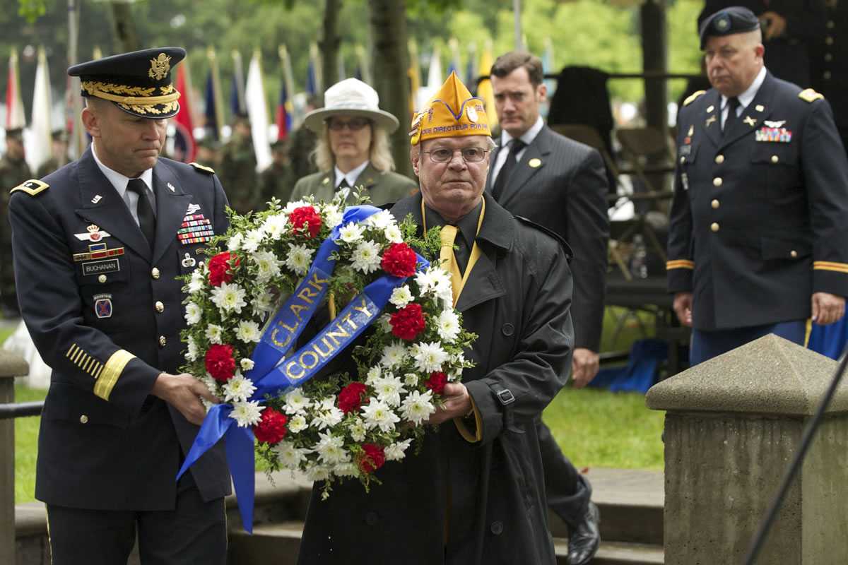 Major General Jeffrey Buchanan, left, and Daniel Tarbell, co-chair of the Community Military Appreciation Committee,  place a wreath to honor fallen soldiers during Vancouver's Memorial Day Observance at the Vancouver Barracks.