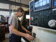 Machinist Rob Koenninger works a CNC lathe inside the machine shop at Applied Motion Systems on Tuesday.