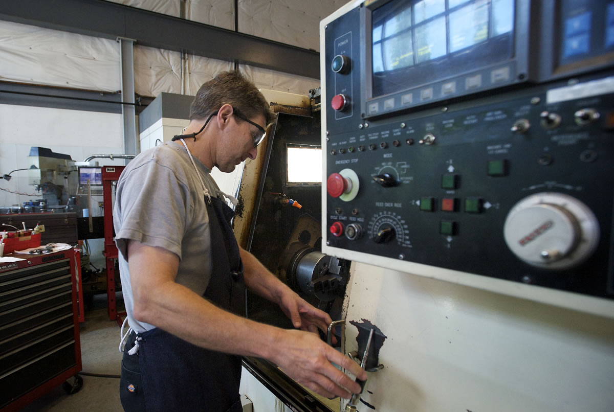 Machinist Rob Koenninger works a CNC lathe inside the machine shop at Applied Motion Systems on Tuesday.