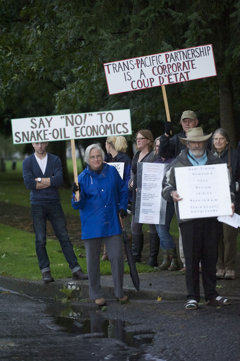 Edie Cotton, center in blue, of Vancouver protests outside Hudson's Bay High School before the start of a public information meeting about an oil terminal proposed at the Port of Vancouver.
