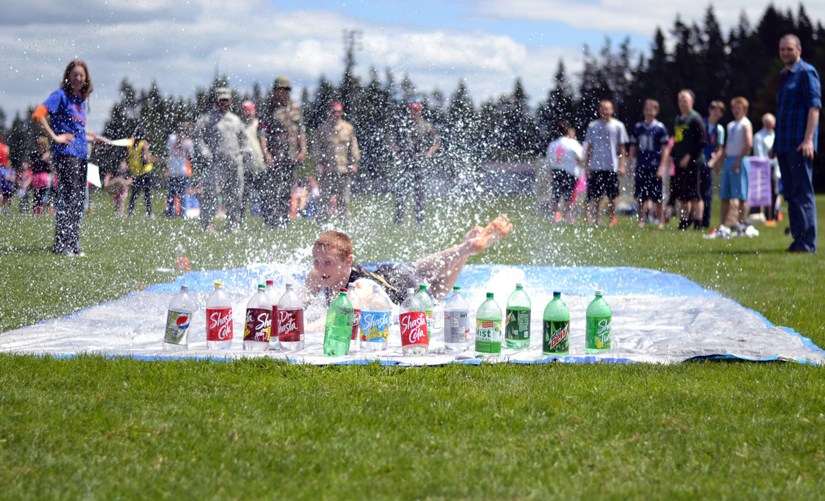 Ridgefield: A Ridgefield High School student celebrates the end of the school year by sliding into a row of plastic pop bottles during the &quot;Human Bowling&quot; event of the school's annual Spudder Olympics celebration May 31.