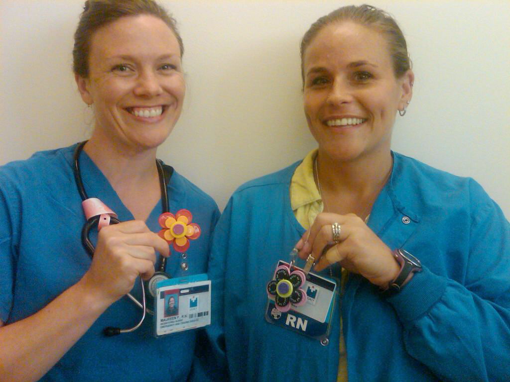 Salmon Creek: Legacy Salmon Creek Medical Center registered nurses Maureen Palensky, left, and Kelly Brady display flower-shaped ID badge holders they created from medicine vial caps. The pair sell the holders for $3 to benefit Legacy's Child Abuse Assessment Team.