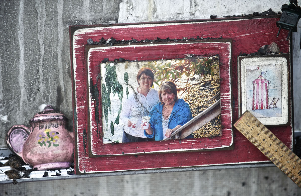 A framed photo sits on the metal edge of a dry erase board inside a burned-out classroom.