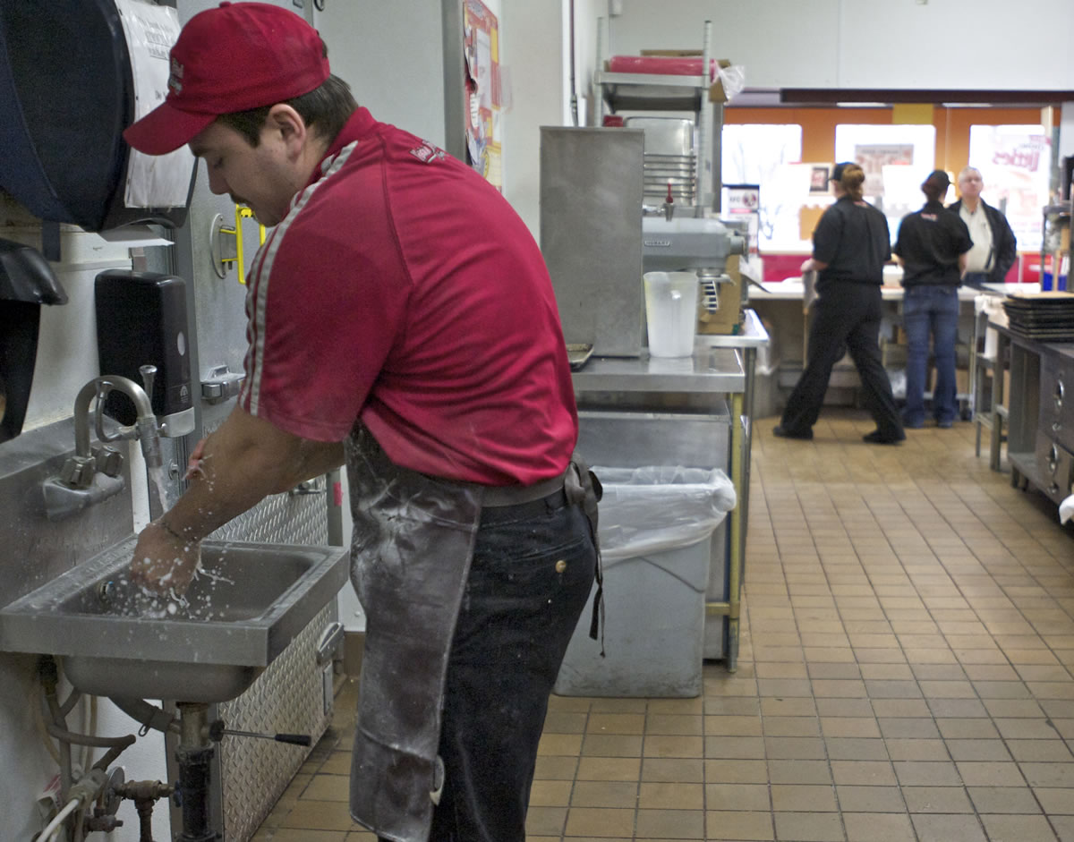 KFC team member Johnny Garcia, 22, washes his hands inside the Hazel Dell quick-service venue.