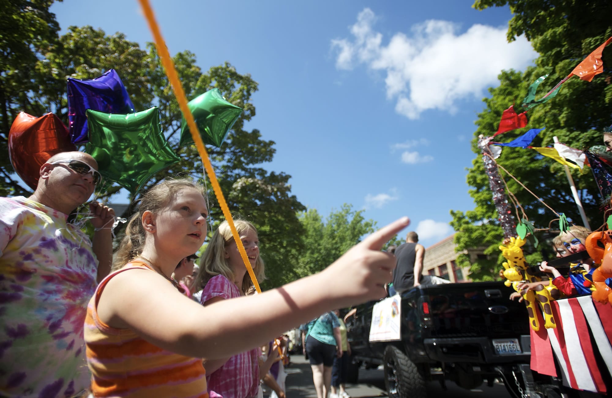 From left, Doug Berg, Emily Berg, 11, and Arianna Stoginais, 10, watch the action go by Saturday during the Camas Days Parade.